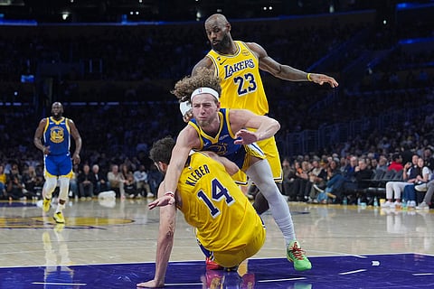 Los Angeles Lakers forward LeBron James (23) watches as forward Maxi Kleber (14) is fouled by Golden State Warriors guard Brandin Podziemski (2) during the first half of an NBA basketball game in Los Angeles.