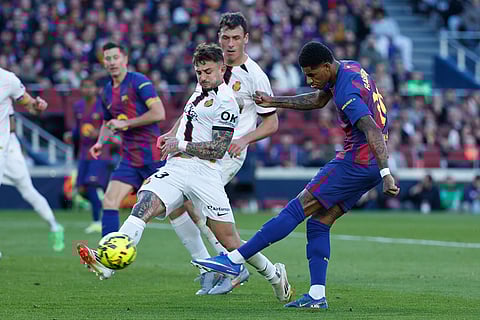 Barcelona's Marcus Rashford, right, attempts a shot on goal as Mallorca's Pablo Maffeo, center, defenses during the Spanish La Liga soccer match between Barcelona and Mallorca in Barcelona, Spain.