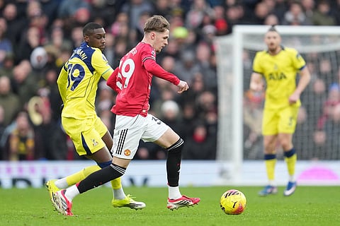 Tottenham's Randal Kolo Muani, left, and Manchester United's Tyler Fletcher fight for the ball during the English Premier League soccer match between Manchester United and Tottenham in Manchester, England.