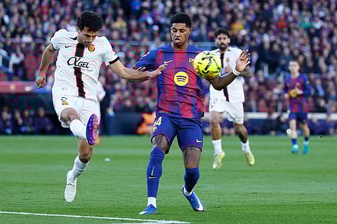 Mallorca's Mateu Morey, left, clears the ball challenged by Barcelona's Marcus Rashford during the Spanish La Liga soccer match between Barcelona and Mallorca in Barcelona, Spain.