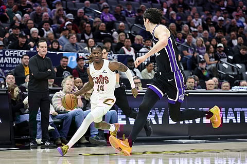 Cleveland Cavaliers guard Keon Ellis (14) drives to the basket with Sacramento Kings center Maxime Raynaud, right, defending during the second half of an NBA basketball game in Sacramento, Calif.