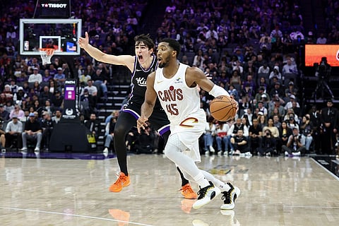 Sacramento Kings center Maxime Raynaud, left, calls for help as Cleveland Cavaliers guard Donovan Mitchell (45) drives to the basket during the second half of an NBA basketball game in Sacramento, Calif.