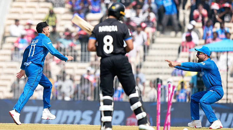 Afghanistan's Mujeeb Ur Rahman, left, celebrates the wicket of New Zealand's Rachin Ravindra, center, with captain Rashid Khan during the T20 World Cup cricket match between Afghanistan and New Zealand in Chennai, India, Sunday, Feb. 8, 2026 - (AP Photo/Mahesh Kumar A.)