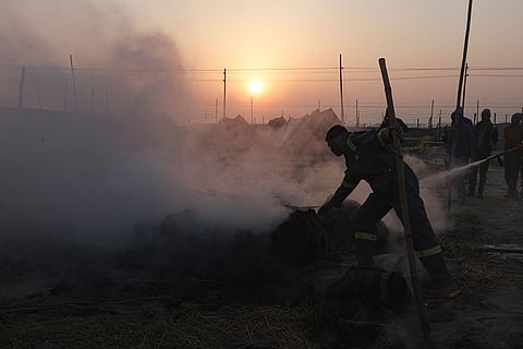 Fire personnel douse a blaze at a camp during the ongoing Magh Mela at Sangam, in Prayagraj.