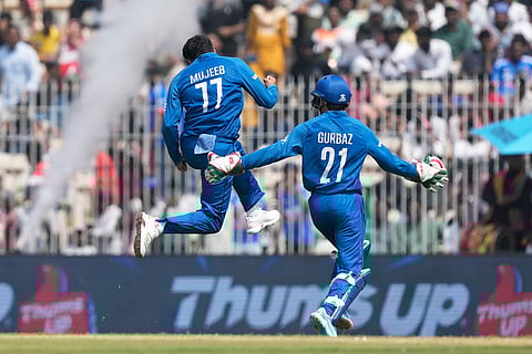Afghanistan's Mujeeb Ur Rahman, left, celebrates the wicket of New Zealand's Rachin Ravindra with teammate Rahmanullah Gurbaz during the T20 World Cup cricket match between Afghanistan and New Zealand in Chennai, India.