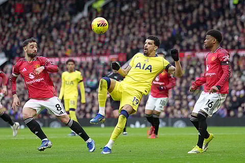 Tottenham's Dominic Solanke receives the ball between Manchester United's Bruno Fernandes, left, and Amad Diallo during the English Premier League soccer match between Manchester United and Tottenham in Manchester, England.