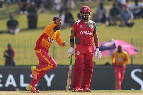 Zimbabwe's captain Sikandar Raza, left, celebrates the wicket of Oman's Wasim Ali during the T20 World Cup cricket match between Oman and Zimbabwe in Colombo, Sri Lanka.