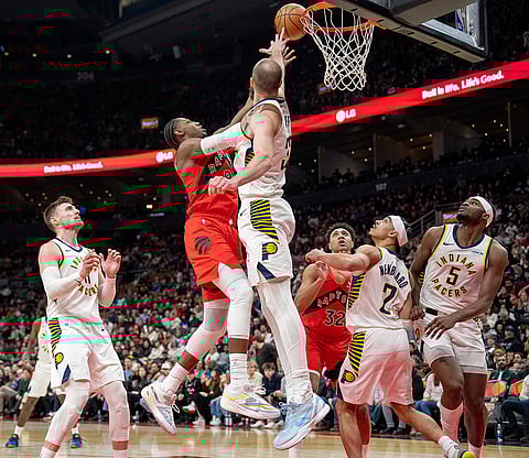 Toronto Raptors forward RJ Barrett, center left, is fouled on his way to the hoop by Indiana Pacers center Jay Huff, center right, during second-half NBA basketball game action in Toronto.