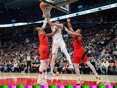 Indiana Pacers centre Jay Huff, center, drives to the hoop between Toronto Raptors forwards R.J. Barrett, left, and Scottie Barnes (4) during first-half NBA basketball game action in Toronto.