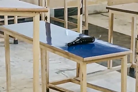 A pistol lies on a desk after a law student shot dead a female classmate inside the classroom before shooting himself, in Tarn Taran district, Punjab.