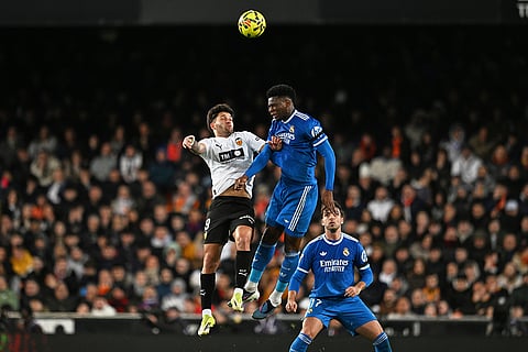 Valencia's Hugo Duro, left, and Real Madrid's Aurelien Tchouameni challenge for the ball during the Spanish La Liga soccer match between Valencia and Real Madrid in Valencia, Spain.