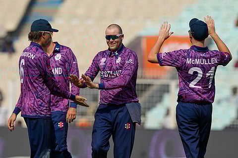 Scotland's Oliver Davidson, left, celebrates the wicket of Italy's Benjamin Manenti with teammates during the T20 World Cup cricket match between Italy and Scotland in Kolkata.