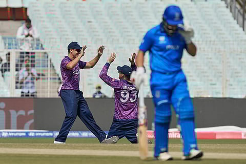 Scotland's George Munsey, center, celebrates the wicket Italy's Justin Mosca, right, of during the T20 World Cup cricket match between Italy and Scotland in Kolkata.