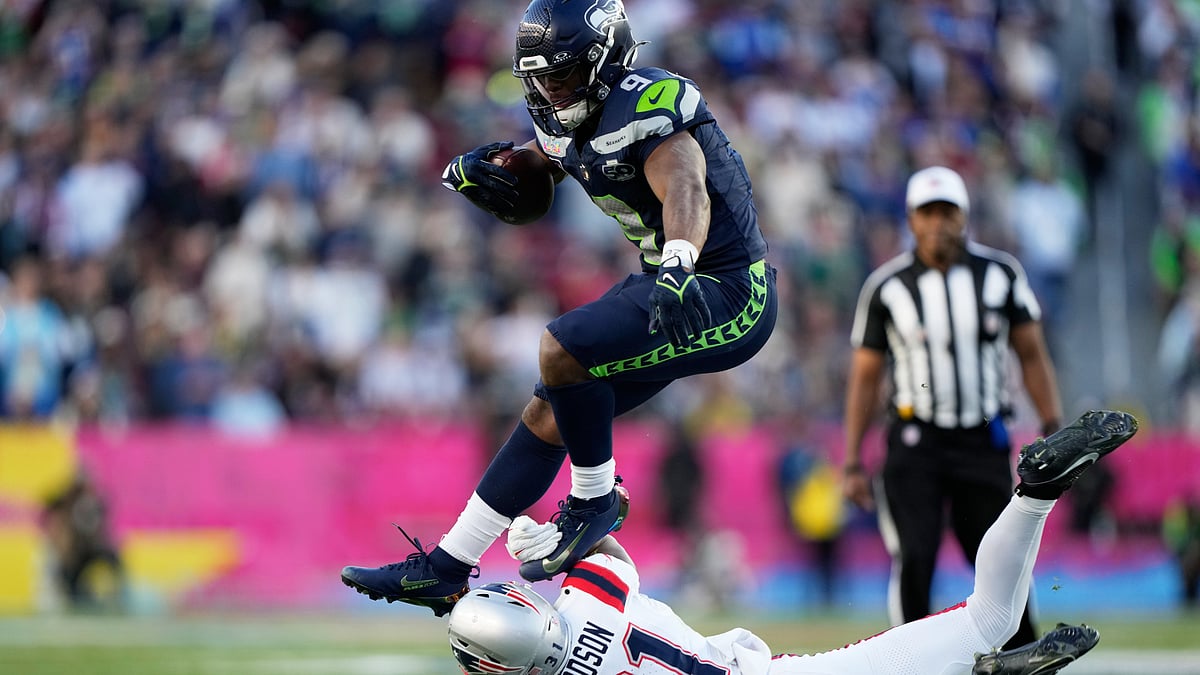 Seattle Seahawks running back Kenneth Walker III, top, runs against New England Patriots safety Craig Woodson (31) during the first half of the NFL Super Bowl 60 football game, Sunday, Feb. 8, 2026, in Santa Clara, Calif. 