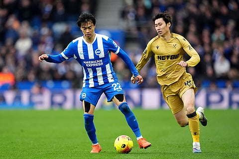 Brighton and Hove Albion's Kaoru Mitoma, left, battle for the ball with Crystal Palace's Daichi Kamada during their English Premier League soccer match in Brighton, England.