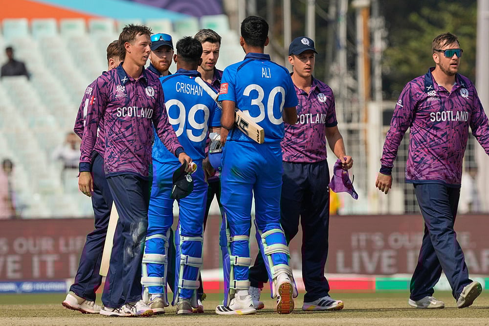 Italy's Ali Hasan and Crishan Jorge congratulate Scotland players on wining the T20 World Cup cricket match in Kolkata. - | Photo: AP/Bikas Das