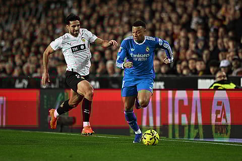 Real Madrid's Kylian Mbappe, right, and Valencia's Eray Comert challenge for the ball during the Spanish La Liga soccer match between Valencia and Real Madrid in Valencia, Spain.