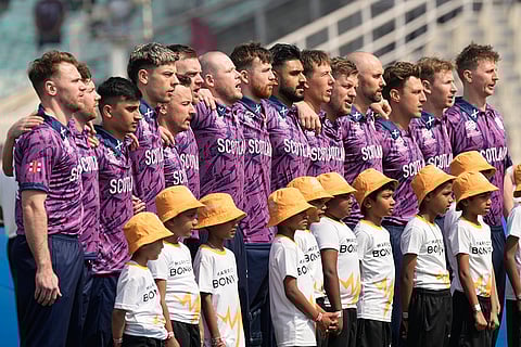 Scotland players stand for the national anthems of the respective countries before the start of the T20 World Cup cricket match between them in Kolkata.