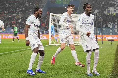 Inter Milan's Yann Bisseck, right, celebrates after scoring their side's first goal of the game during the Serie A soccer match between Sassuolo and Inter in Milan, Italy.