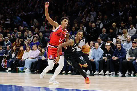 Minnesota Timberwolves guard Bones Hyland (8) drives to the basket while Los Angeles Clippers guard Cam Christie (12) defends during the first half of an NBA basketball game in Minneapolis. 