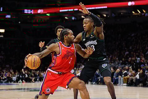 Los Angeles Clippers forward Kawhi Leonard (2) dribbles while Minnesota Timberwolves guard Ayo Dosunmu, right, defends during the second half of an NBA basketball game in Minneapolis.