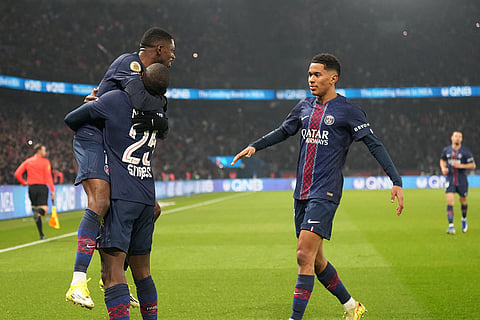 PSG's Ousmane Dembele, top, celebrates with teammates after scoring the opening goal during the French League One soccer match between Paris Saint-Germain and Marseille in Paris.