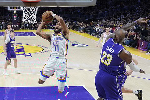 Oklahoma City Thunder guard Isaiah Joe (11) puts up a shot against Los Angeles Lakers forward LeBron James (23) during the first half of an NBA basketball game in Los Angeles.