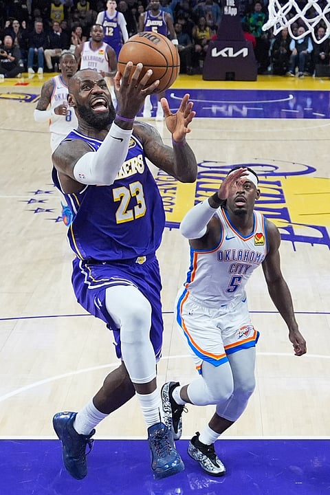 Los Angeles Lakers forward LeBron James (23) goes up for a basket past Oklahoma City Thunder guard Luguentz Dort (5) during the second half of an NBA basketball game in Los Angeles. 