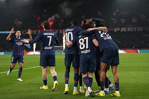 PSG's Khvicha Kvaratskhelia celebrates with teammates after scoring his side's fourth goal during the French League One soccer match between Paris Saint-Germain and Marseille in Paris.
