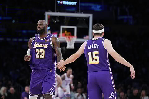 Los Angeles Lakers forward LeBron James (23) and guard Austin Reaves (15) celebrate a basket during the second half of an NBA basketball game against the Oklahoma City Thunder in Los Angeles. 