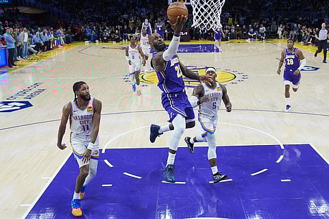 Los Angeles Lakers forward LeBron James (23) puts up a shot as Oklahoma City Thunder guard Isaiah Joe (11) and guard Luguentz Dort (5) watch during the second half of an NBA basketball game in Los Angeles.
