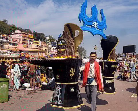 A man carries ceremonial objects called, 'Kanwar', ahead of the 'Mahashivratri' festival, in Haridwar, Uttarakhand.