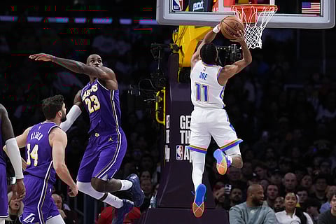 Oklahoma City Thunder guard Isaiah Joe (11) goes up for a basket as Los Angeles Lakers forward LeBron James (23) watches during the first half of an NBA basketball game in Los Angeles. 