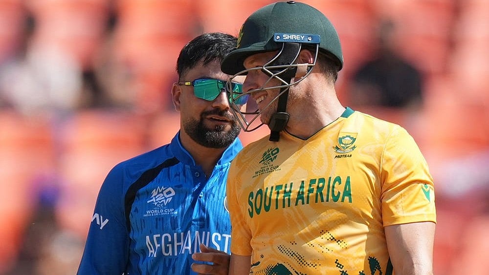 | Photo: AP/Ajit Solanki : Afghanistan's captain Rashid Khan, left shares a light moment with South Africa's David Miller during the T20 World Cup cricket match between Afghanistan and South Africa in Ahmedabad.