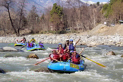 People enjoy river rafting in the Beas river, in Kullu district.