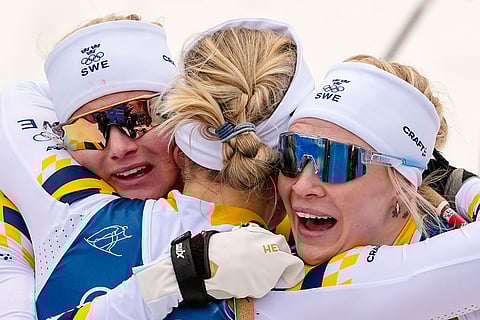 Gold medalist Linn Svahn, of Sweden, center, hugs silver medalist Jonna Sundling, right, and bronze medalist Maja Dahlqvist, both also of Sweden, after the cross-country skiing women's sprint classic at the 2026 Winter Olympics, in Tesero, Italy.