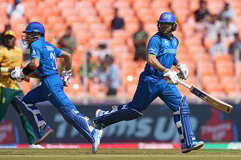 Afghanistan's Rahmanullah Gurbaz, left and Darwish Rasooli run between the wickets to score during the T20 World Cup cricket match between Afghanistan and South Africa in Ahmedabad.