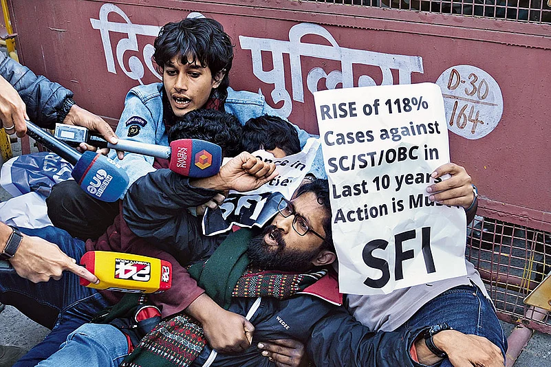 Delhi police detain an activist from the Students’ Federation of India during a protest in Delhi