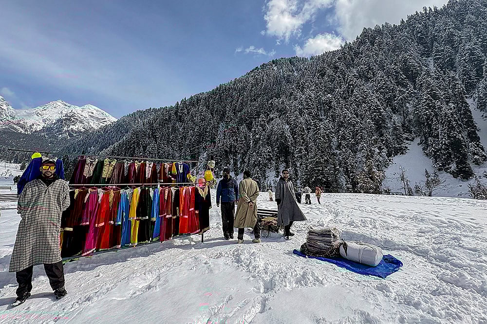 Vendors put up a clothing stall during the 'Snow Festival' at Aru Valley, in Anantnag, Jammu and Kashmir. - | Photo: PTI