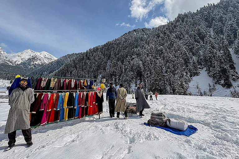 Vendors put up a clothing stall during the 'Snow Festival' at Aru Valley, in Anantnag, Jammu and Kashmir. - | Photo: PTI