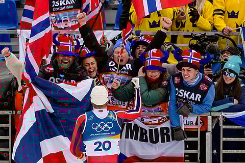 Oskar Opstad Vike, of Norway, celebrates with fans after winning the bronze medal in the cross-country skiing men's sprint classic at the 2026 Winter Olympics, in Tesero, Italy.