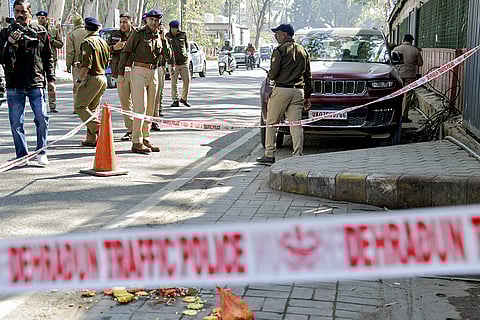 Police personnel investigate the spot after a man was shot dead near Tibetan Market, in Dehradun.