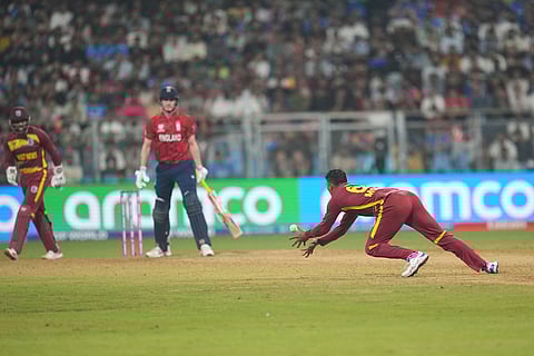 West Indies' Gudakesh Motie takes a catch off his own bowling to dismiss England's captain Harry Brook, centre, during the T20 World Cup cricket match between England and West Indies in Mumbai, India.