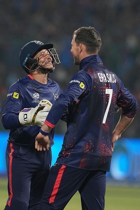 Namibia's Zane Green, left, and captain Gerhard Erasmus celebrate the wicket of India's Tilak Varma during the T20 World Cup cricket match between India and Namibia in New Delhi.