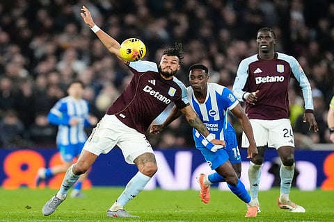 Aston Villa's Tyrone Mings, center left, and Brighton and Hove Albion's Danny Welbeck, center right, vie for the ball during their English Premier League soccer match in Birmingham, England.