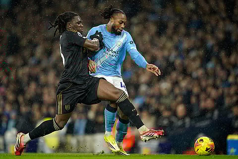Fulham's Calvin Bassey, left, and Manchester City's Antoine Semenyo challenge for the ball during the English Premier League soccer match between Manchester City and Fulham in Manchester, England.