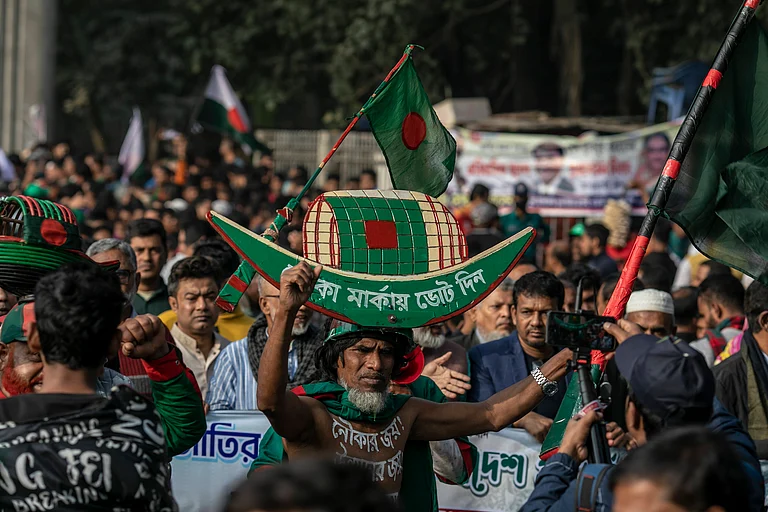 A supporter of Bangladesh's ruling Awami League party is seen carrying the party's election symbol boat on his head as he arrives at Suhrawardy Udyan to attend a public rally. The Awami League leaders and activists gathered at Suhrawardy Udyan to attend a public rally organized to commemorate the historic homecoming day of the Father of the Nation, Bangabandhu Sheikh Mujibur Rahman. - IMAGO / ZUMA Press Wire