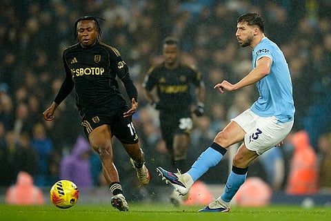 Manchester City's Ruben Dias, right, and Fulham's Samuel Chukwueze challenge for the ball during the English Premier League soccer match between Manchester City and Fulham in Manchester, England.