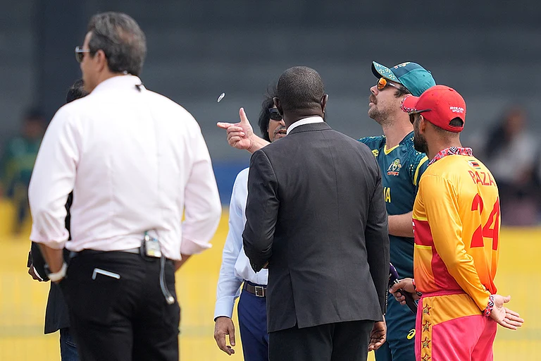 Australia's captain Travis Head, second right, toss the coin as Zimbabwe's captain Sikandar Raza, right, watch it before the starts of the T20 World Cup cricket match between Australia and Zimbabwe in Colombo, Sri Lanka. - | Photo: AP/Eranga Jayawardena