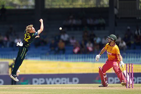 Australia's Nathan Ellis, left, jumps to catch a ball as Zimbabwe's Ryan Burl, right, watch during the T20 World Cup cricket match between Australia and Zimbabwe in Colombo, Sri Lanka.